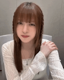 a girl with long hair and bangs is wearing a white shirt