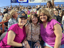 three women are posing for a picture in front of a crowd with a sign that says action news in the background
