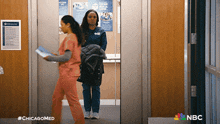 two nurses are walking out of an elevator and the hashtag #chicagomed is on the bottom right