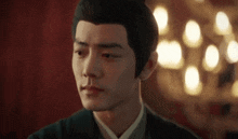 a close up of a man 's face with a blurry background of lights behind him .