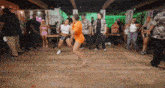 a group of people are dancing in a room with a sign that says eat nite