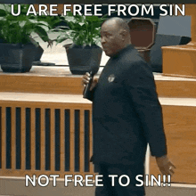 a man speaking into a microphone with a caption that says u are free from sin not free to sin