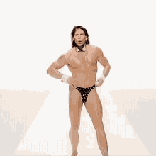 a shirtless man with long hair wearing a bow tie and underwear