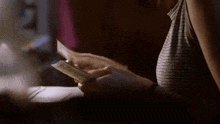 a woman in a striped shirt is holding a piece of paper in her hand