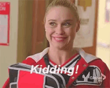 a cheerleader is smiling while holding a bag that says kidding