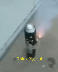 a spray can that says think big huh is on the floor