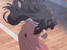a girl with long hair is covering her face with her hand