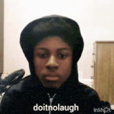 a young man wearing a hoodie is making a funny face and says `` doitnolaugh '' .