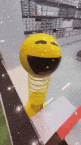 a yellow ball with a smiley face on it is on a spring
