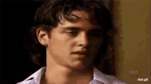 a close up of a young man 's face with a sbt logo in the background