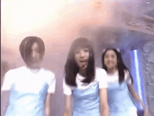 a group of young women are dancing in a room .