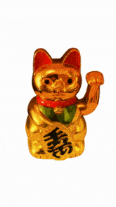 a small gold statue of a cat with a red collar