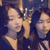 a couple of girls are standing next to each other in a dark room .