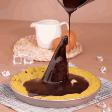 a pie with chocolate being poured on it looks like a witch 's hat