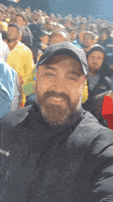 a man with a beard is smiling in front of a crowd of people