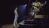 a man without a shirt is singing into a microphone on stage