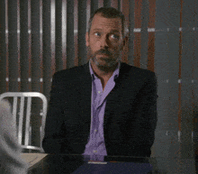 a man in a suit is sitting at a table