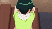 a girl in a green shirt sits on a couch with nbds sama written on the bottom right
