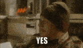 a man wearing a beanie and plaid shirt is saying yes