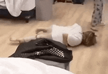 a person is laying on the floor in a room with clothes on the floor .