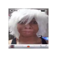 a person wearing a white wig is taking a picture of themselves