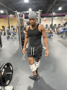 a man stands in a gym with a sign that says fitness