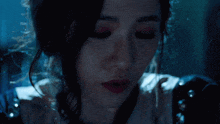 a woman in a dark room with her eyes closed