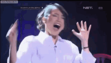 a woman in a white shirt is screaming on a television show