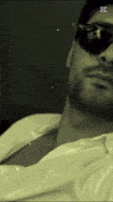 a close up of a man wearing sunglasses and a shirt