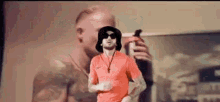 a man wearing sunglasses and a hat is running in front of a painting .