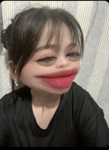 a woman wearing a black shirt has a big mouth and red lipstick on her lips