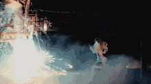a fireworks display at night with smoke and sparks