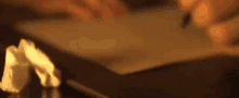 a person is cutting a piece of paper with a knife on a table .