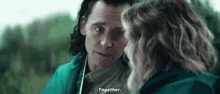 a man and a woman are looking into each other 's eyes and talking to each other .