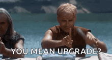 two men are sitting at a table and one of them is pointing at the other and says you mean upgrade .