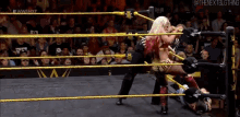 a woman is wrestling another woman in a wrestling ring
