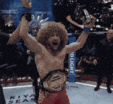a man in a boxing ring with a bud light sign behind him