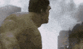 the hulk is standing in front of a city in a movie scene .