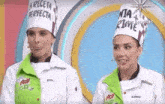 two women wearing chef 's hats are standing next to each other on a stage .