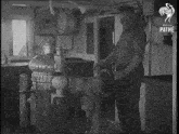a black and white photo of a man behind a steering wheel with pathe written on the bottom
