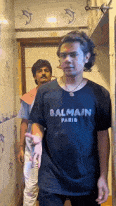 a man wearing a black balmain paris shirt