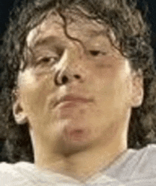 a close up of a man 's face with curly hair looking at the camera .