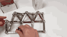 a person is playing with a set of metal blocks and balls