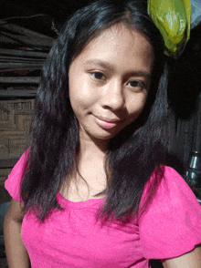 a girl wearing a pink shirt is smiling for the camera