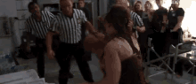 a group of people are standing around a boxing match between two women .