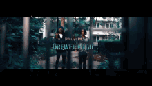 a couple of people standing in front of a fence with the word drew in the background