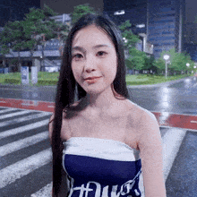 a woman wearing a blue and white strapless top with the letter x on the front