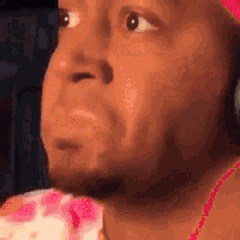 a close up of a man 's face with a pink hat
