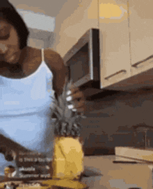 a woman is cutting a pineapple with a knife