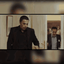 a man in a suit stands in front of a door in a room